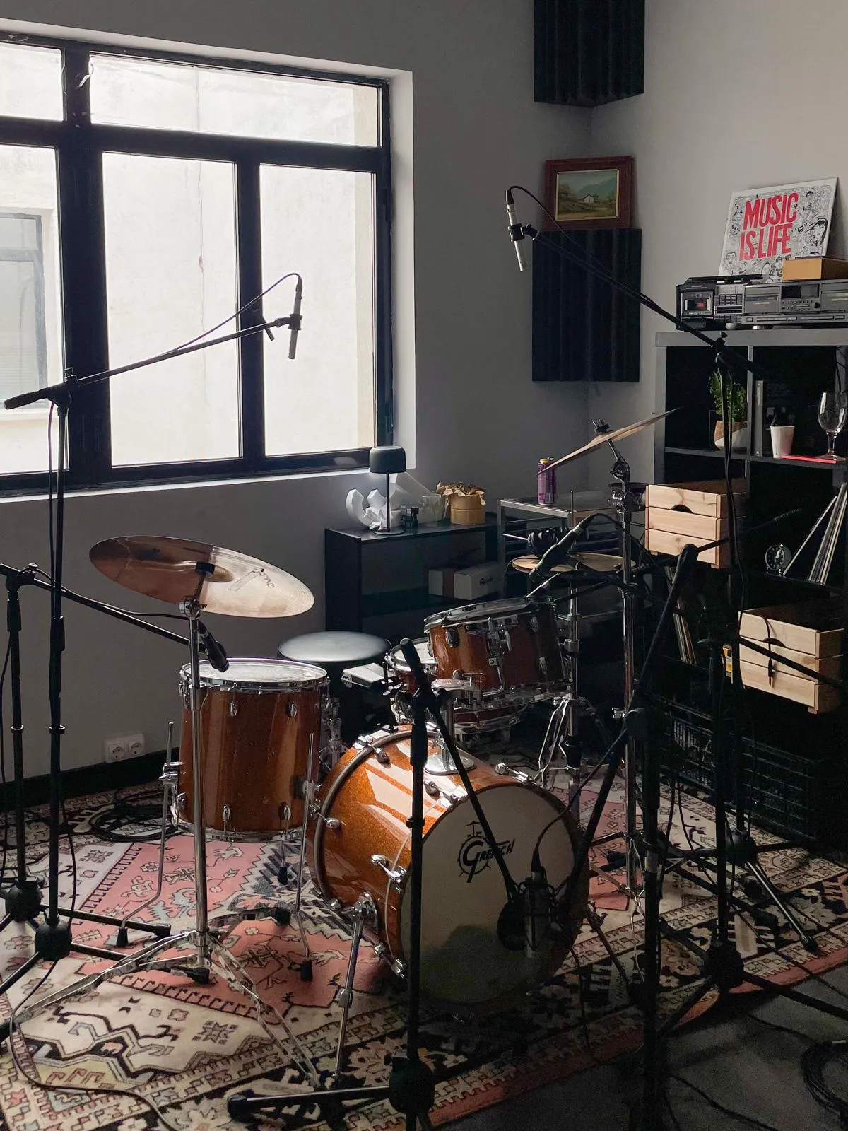 Batería Gretsch microfoneada en la sala de grabación, sobre una alfombra